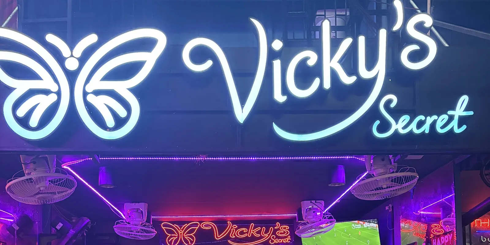 The glowing butterfly sign and neon-lit front of Vicky's Secret on Soi Cowboy