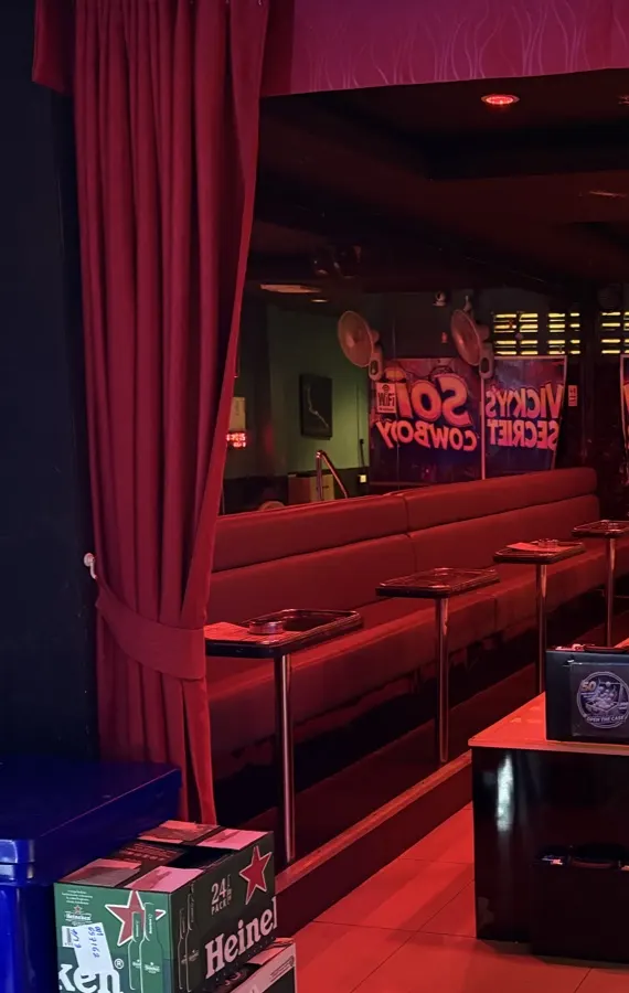 Red curtains and red lounge seating with small drinks tables